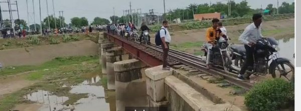 रेलवे ट्रैक बना राह, बाइक और पैदल चल पड़े लोग; जरा सी चूक बन सकती थी मौत का कारण